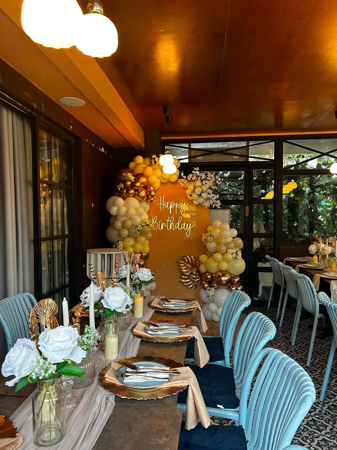 Flossom birthday event with gold and yellow balloon garland and garden view